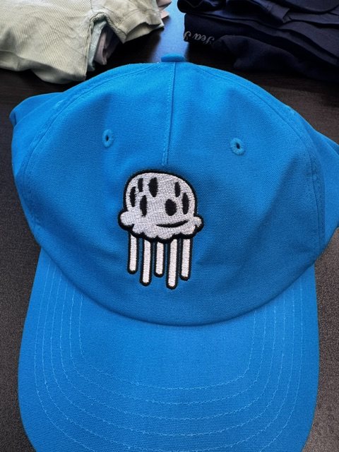 Bright blue snapback cap with an embroidered patch of a skull holding two pickleball paddles